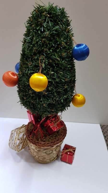 Vintage Christmas decoration. Small Christmas tree in basket with gifts under the tree