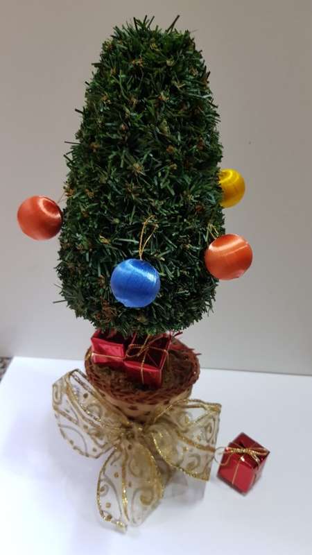 Vintage Christmas decoration. Small Christmas tree in basket with gifts under the tree