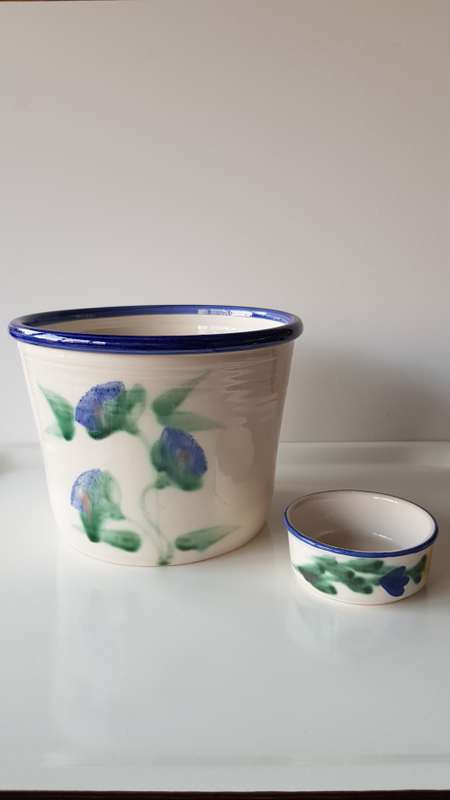 Indoor flower pot/planter. Ceramic glazed flower pot white with blue trim on rim and a blue flower