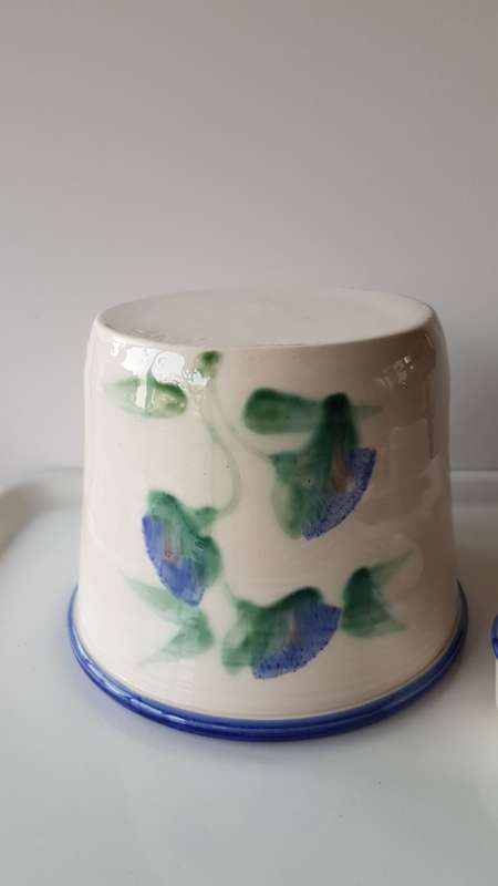 Indoor flower pot/planter. Ceramic glazed flower pot white with blue trim on rim and a blue flower