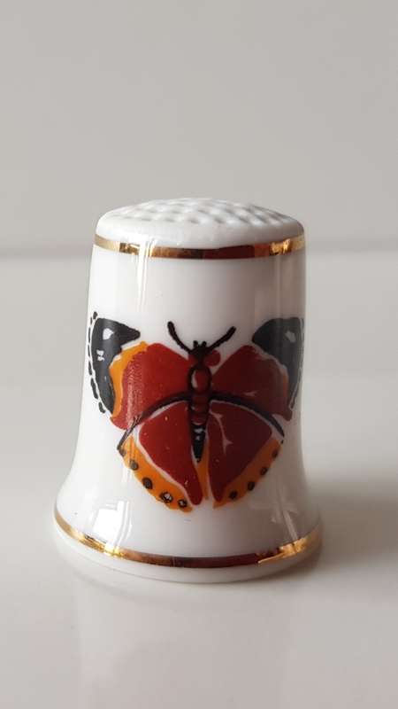 A Vintage collectors thimble. Thimble has two painted butterflies