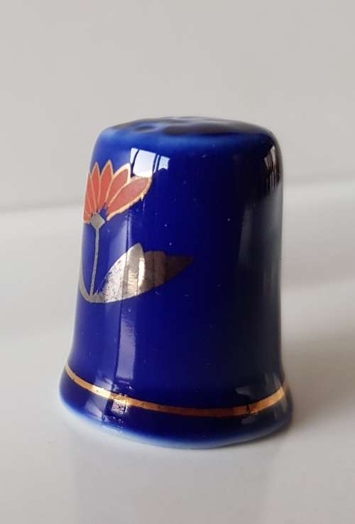 A Vintage collectors thimble. Thimble in blue glaze, painted flower in front