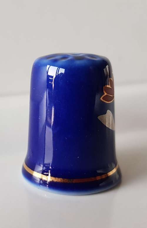 A Vintage collectors thimble. Thimble in blue glaze, painted flower in front
