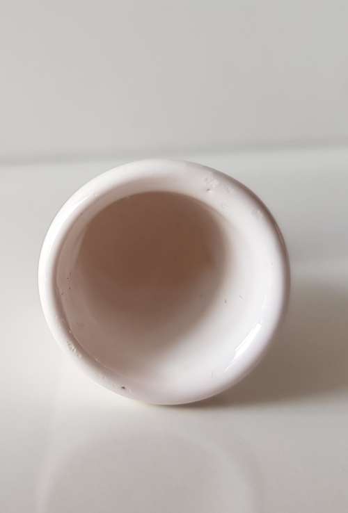 A Vintage collectors thimble. A white ceramic Thimble with painted flower in front.