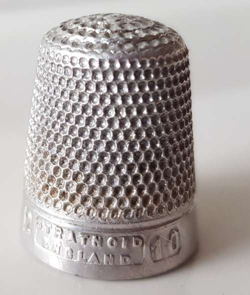 A Vintage collectors aluminium thimble. Thimble is marked with a number 2 and the name Stratnoid