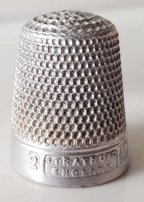 A Vintage collectors aluminium thimble. Thimble is marked with a number 2 and the name Stratnoid