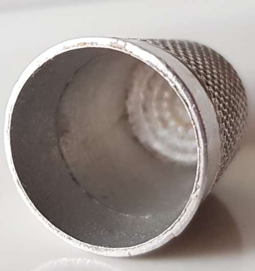 A Vintage collectors aluminium thimble. Thimble is marked with a number 2 and the name Stratnoid