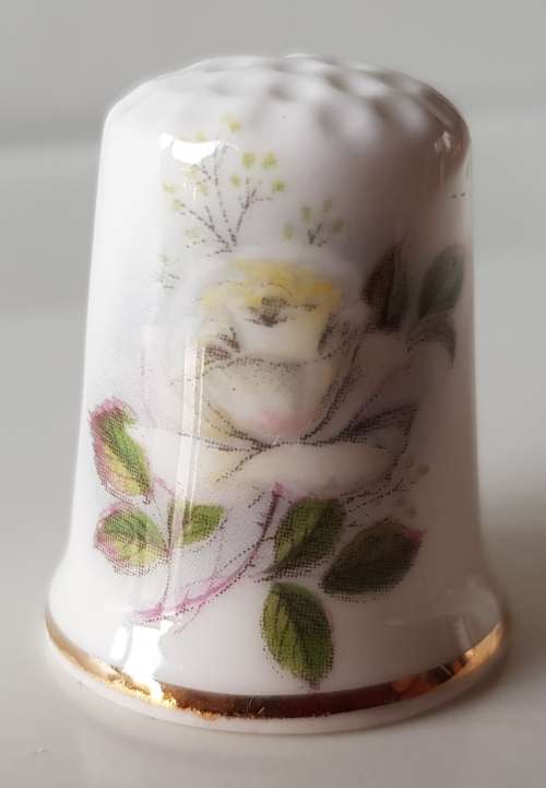 A Vintage collectors thimble. Thimble has painted roses in front