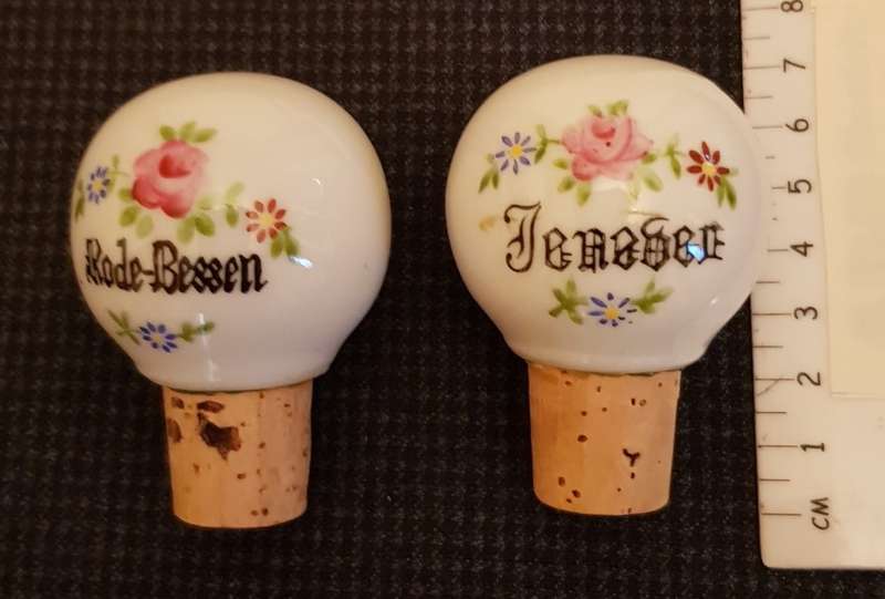 Vintage porcelain bottle stoppers marked Jenever and Rode-Besse.