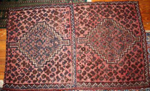 Vintage hand-knotted BaIouchi rug boasting tribaI patterns.