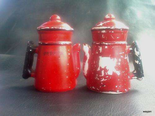 OLD RETRO SALT AND PEPPER POTS. PLEASE NOTE THE PAINT DAMAGE AND WORDING. ONE NEEDS A STOPPER. RED.