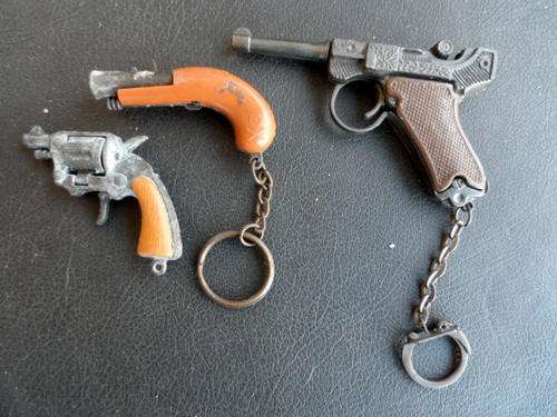 3 SMALL KEYRING CAP GUNS. 1 MISSING TRIGGER AND ONE MISSING KEYCHAIN. SOME RUSTING.