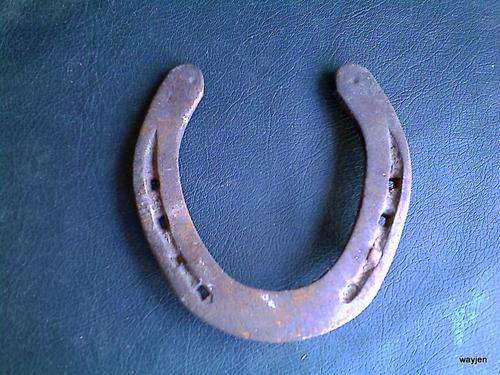 SOLID STEEL HORSESHOE. HORSESHOES ARE BELIEVED TO BE PROTECTORS OF BUILDINGS. THESE ARE WELL WORN.