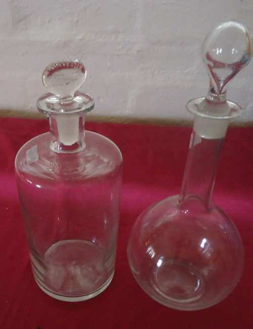 TWO LARGE SIZE VINTAGE CLEAR CHEMIST-APOTHECARY BOTTLES WITH INTERESTING GLASS STOPPERS- SEE PHOTOS
