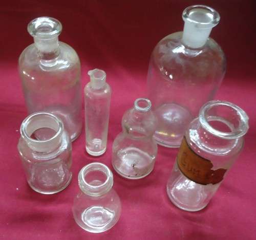 SEVEN DIFFERENT ROUND CLEAR VINTAGE CHEMIST-APOTHECARY BOTTLES-SEE PHOTOS
