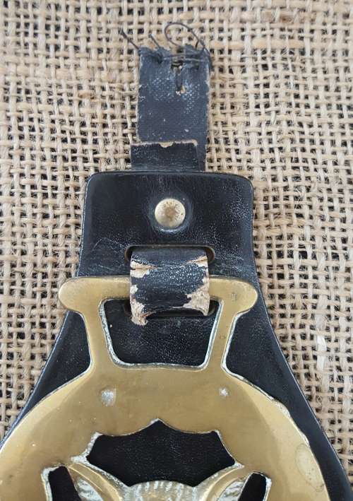 A TRIO OF OLD HORSE BRASSES ON A LEATHER STRAP
