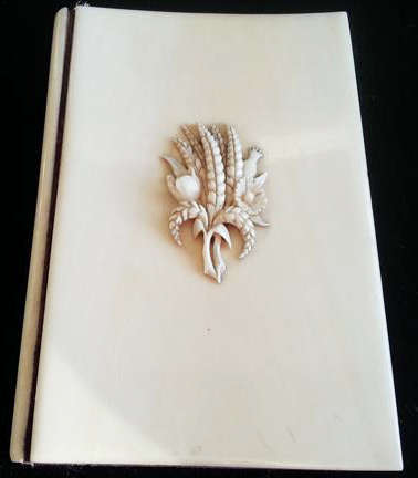 ANTIQUE  IVORY CASED NOTEBOOK AND PENCIL,  FRONT COVER DECORATED WITH WHEAT AND FIELD FLOWERS