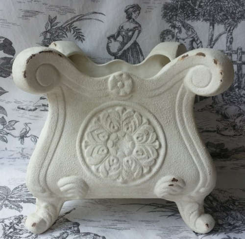 ATTRACTIVE, PAINTED OFF WHITE, ANTIQUED METAL POT PLANT HOLDER ON FOUR LEGS.