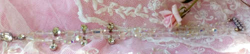 A SPARKLING SINGLE STRAND CRYSTAL NECKLACE WITH 6 SIDE DROP CRYSTALS AND A CENTRAL DROP PENDANT