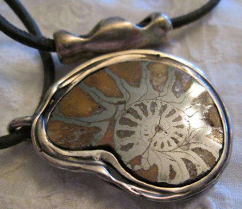 POLISHED AMMONITE FOSSIL, SET IN SILVER 925 AS A PENDANT WITH A THIN LEATHER "LACE"