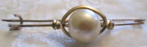 VINTAGE BAR BROOCH WITH A FAUX ? PEARL SET INGILT METAL WITH A C SHAPE CLASP.