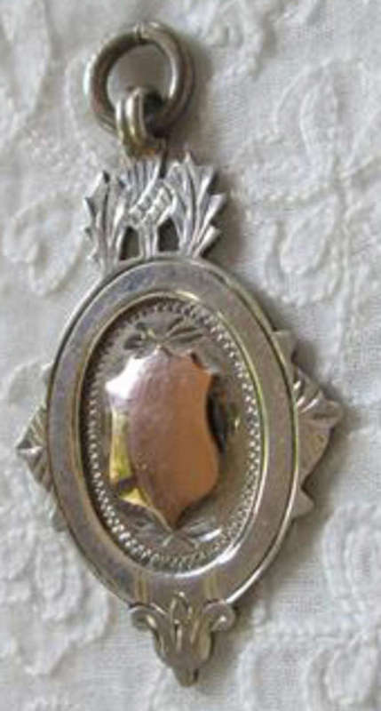 EDWARDIAN 1925  SILVER FOB PENDANT WITH GOLD CENTRE AND SCOTTISH THISTLE DESIGN.