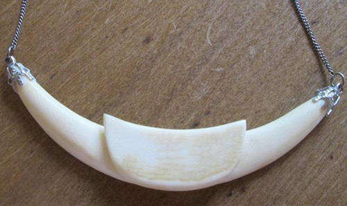 VINTAGE ETHNIC LOOKING IVORY NECKLACE ATTATCHED TO A SILVER METAL CHAIN.