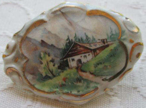 VINTAGE PORCELAIN BROOCH WITH AN ALPINE SCENE.