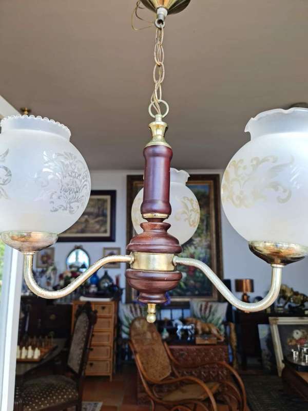 Three arm chandelier with glass shades. Lovely wood and brass details.