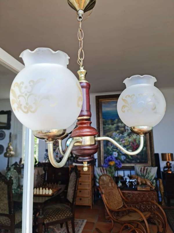 Three arm chandelier with glass shades. Lovely wood and brass details.
