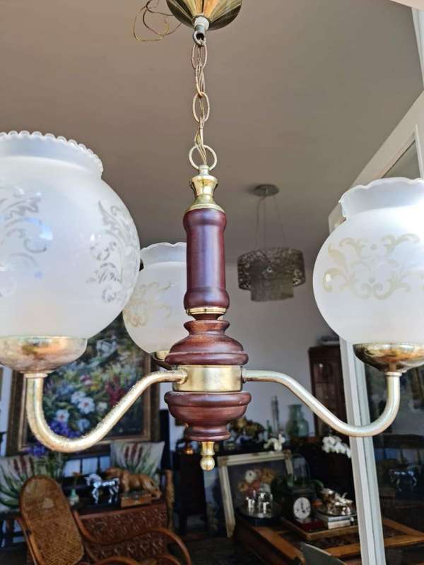 Three arm chandelier with glass shades. Lovely wood and brass details.