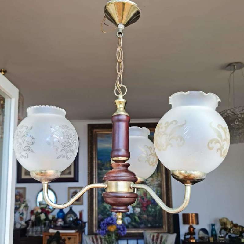 Three arm chandelier with glass shades. Lovely wood and brass details.