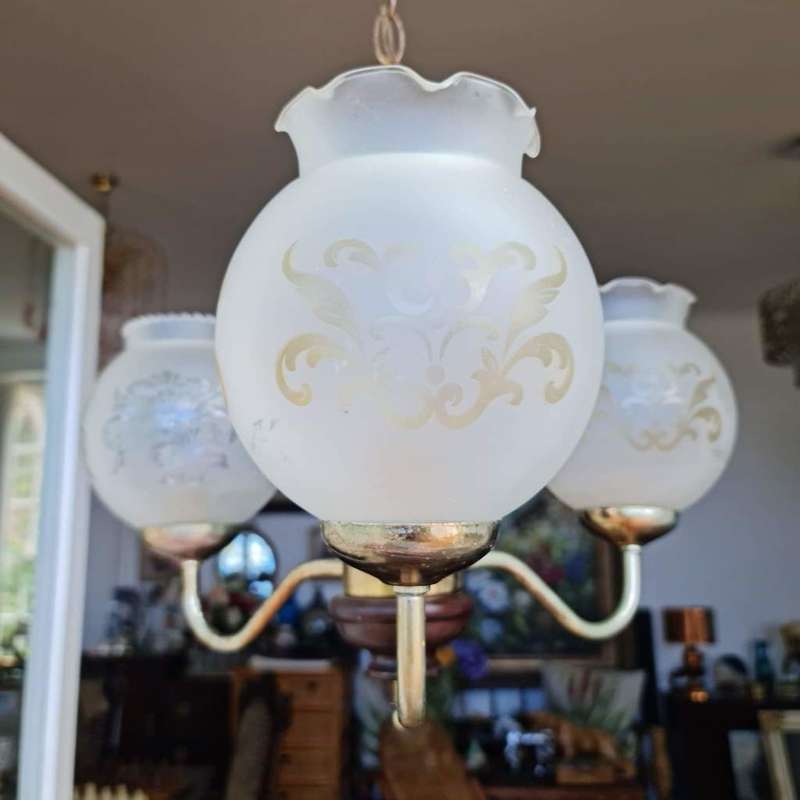 Three arm chandelier with glass shades. Lovely wood and brass details.
