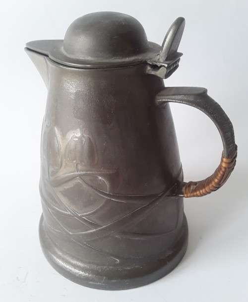 Antique Arts and Crafts pewter jug in the style of Liberty and Co. Hand-beaten lily pattern.