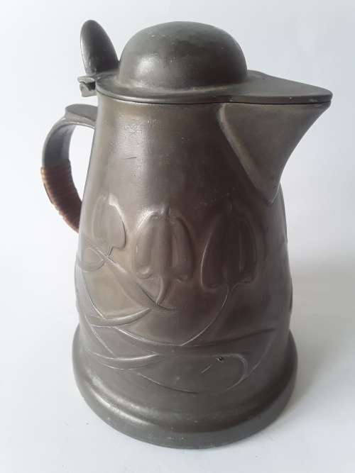 Antique Arts and Crafts pewter jug in the style of Liberty and Co. Hand-beaten lily pattern.