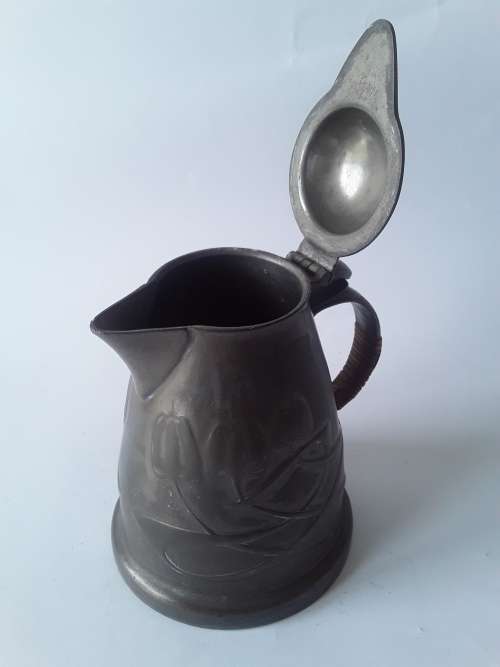 Antique Arts and Crafts pewter jug in the style of Liberty and Co. Hand-beaten lily pattern.