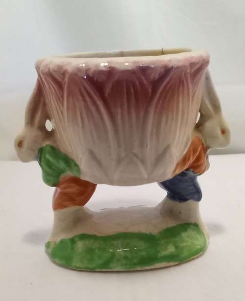 Nostalgic vintage porcelain petal vase held by two bunnies