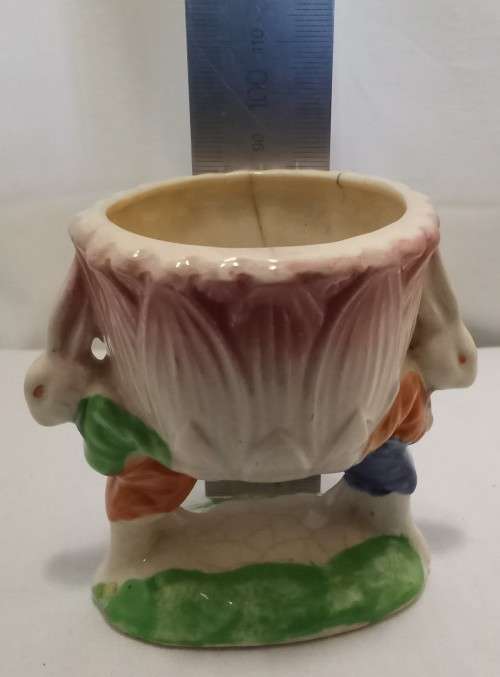 Nostalgic vintage porcelain petal vase held by two bunnies