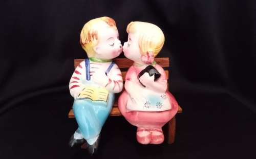 Cutest vintage kissing couple on wooden bench by Balboa