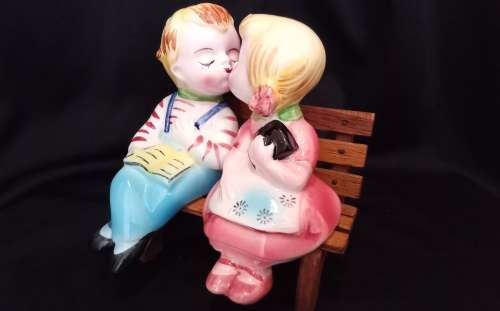 Cutest vintage kissing couple on wooden bench by Balboa
