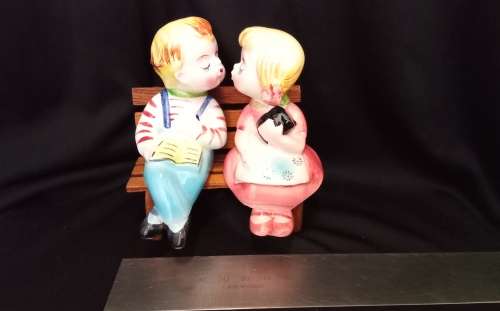 Cutest vintage kissing couple on wooden bench by Balboa