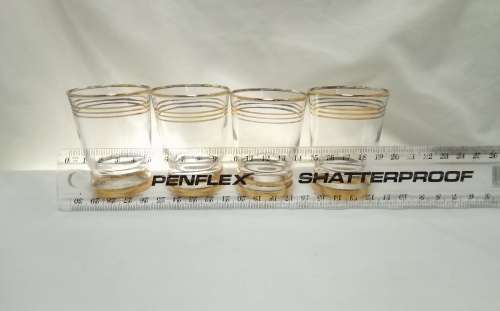 Four beautiful vintage gold rimmed little drinking glasses
