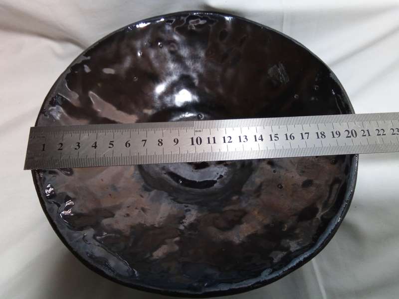 Stunning solid pottery bowl with a dark iridescent glaze inside