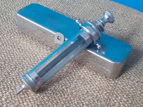 Antique glass syringe with original tin