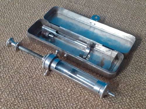 Antique glass syringe with original tin