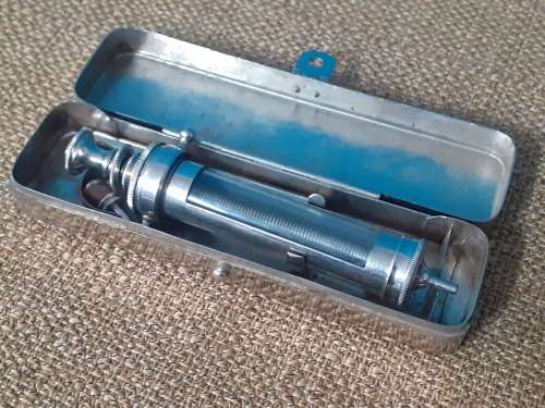 Antique glass syringe with original tin
