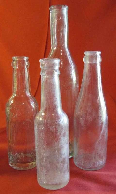 Four Clear Pressed Glass Bottles by Various Makers