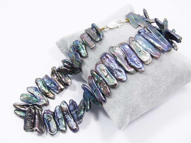 A Beautiful String Of Free Form Peacock Color Pearl Necklace With a Sterling Silver Clasp.