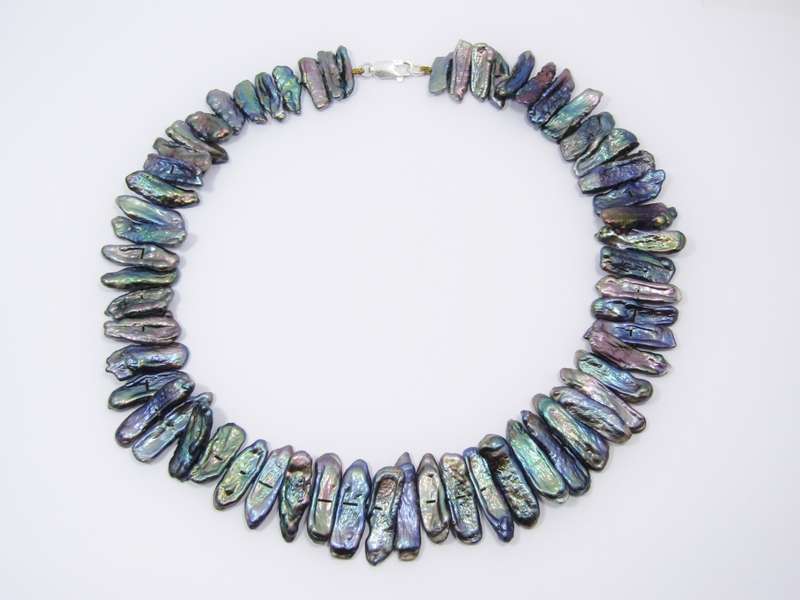 A Beautiful String Of Free Form Peacock Color Pearl Necklace With a Sterling Silver Clasp.