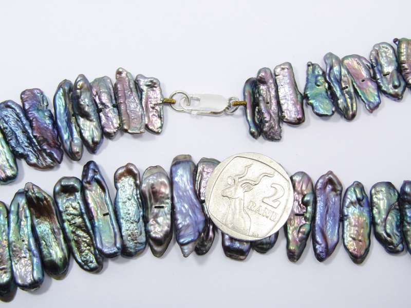 A Beautiful String Of Free Form Peacock Color Pearl Necklace With a Sterling Silver Clasp.